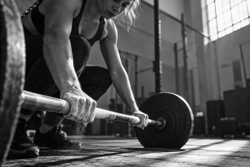 Campaign image of a woman preparing for a barbell lift